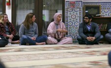 People of different ethnicities sitting on the floor conversing