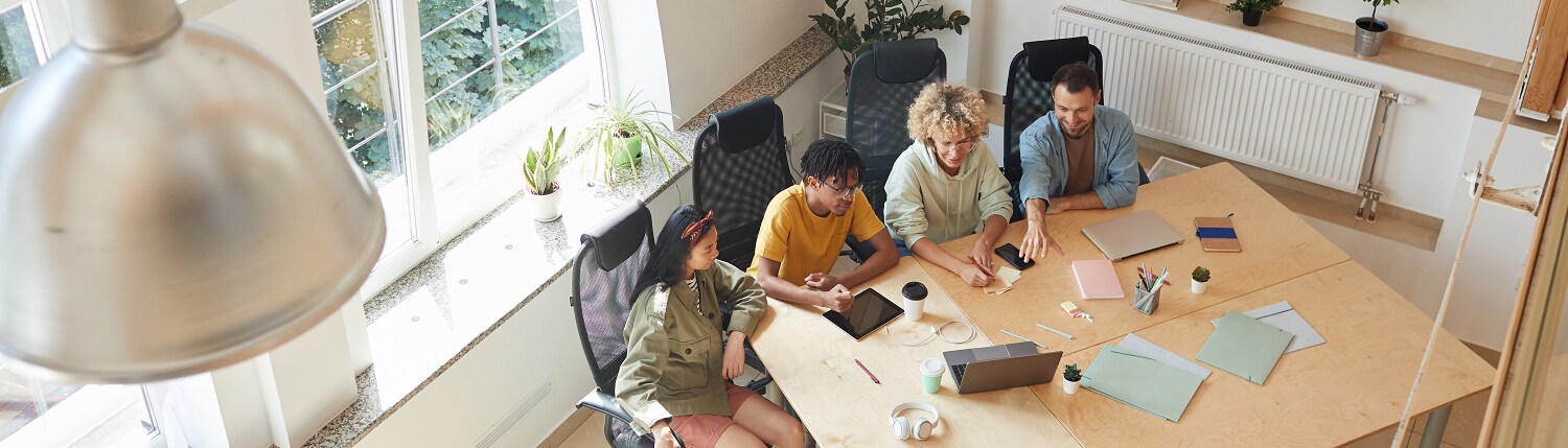 Four colleagues sitting at one side of a conference table