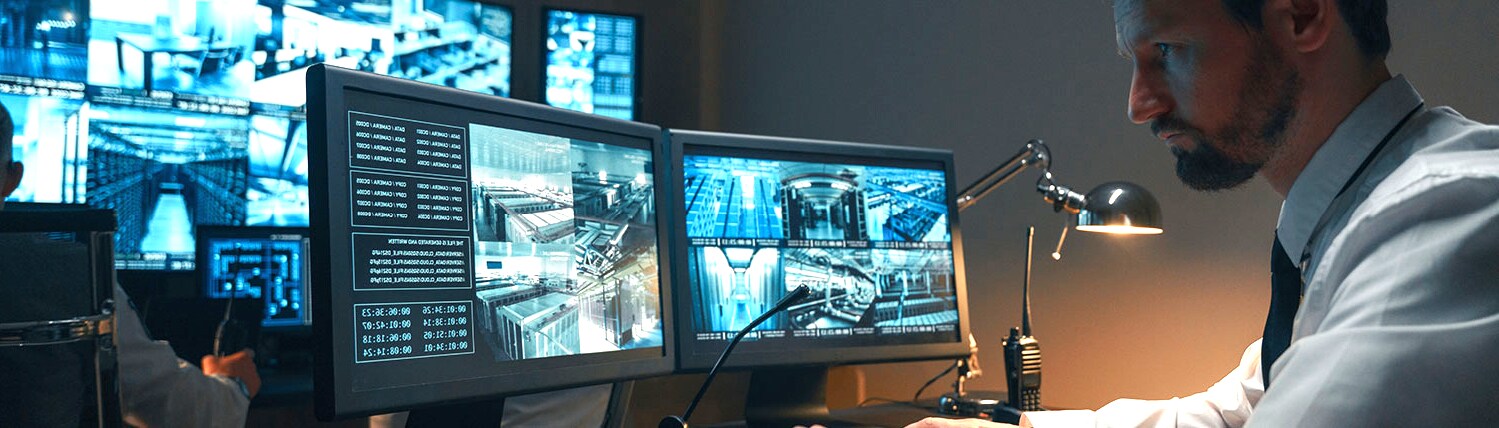 Man concentrating at video surveillance footages in a security room